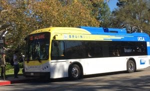 An electric bus boards passengers at UCLA